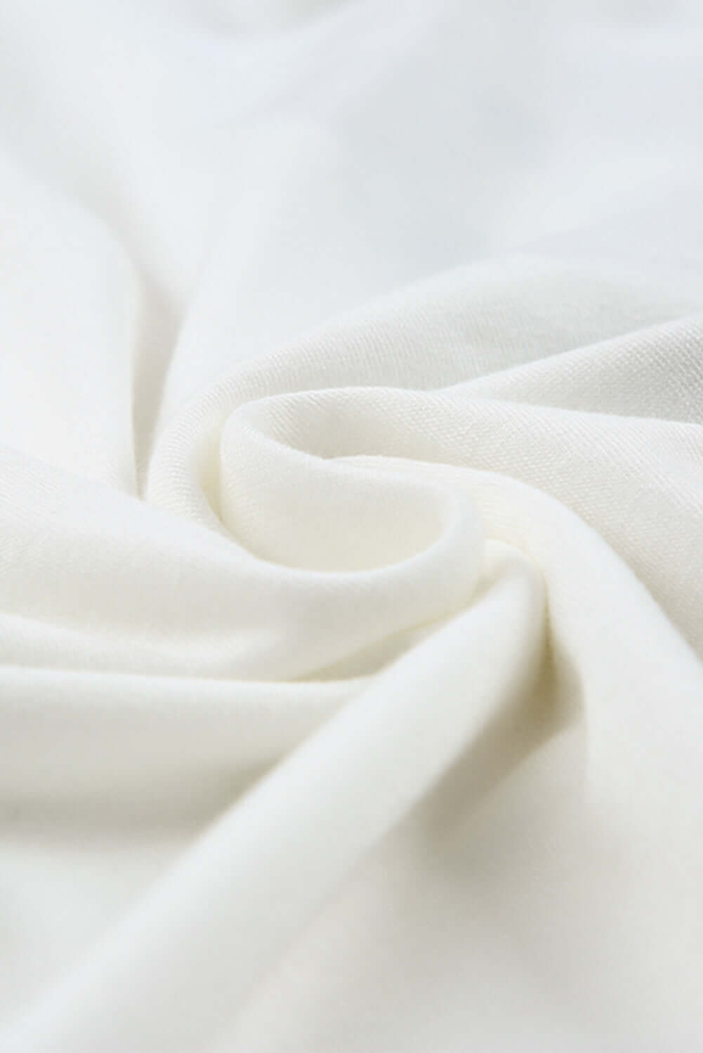 Close-up of soft, white fabric showcasing its smooth texture and elegant drape.