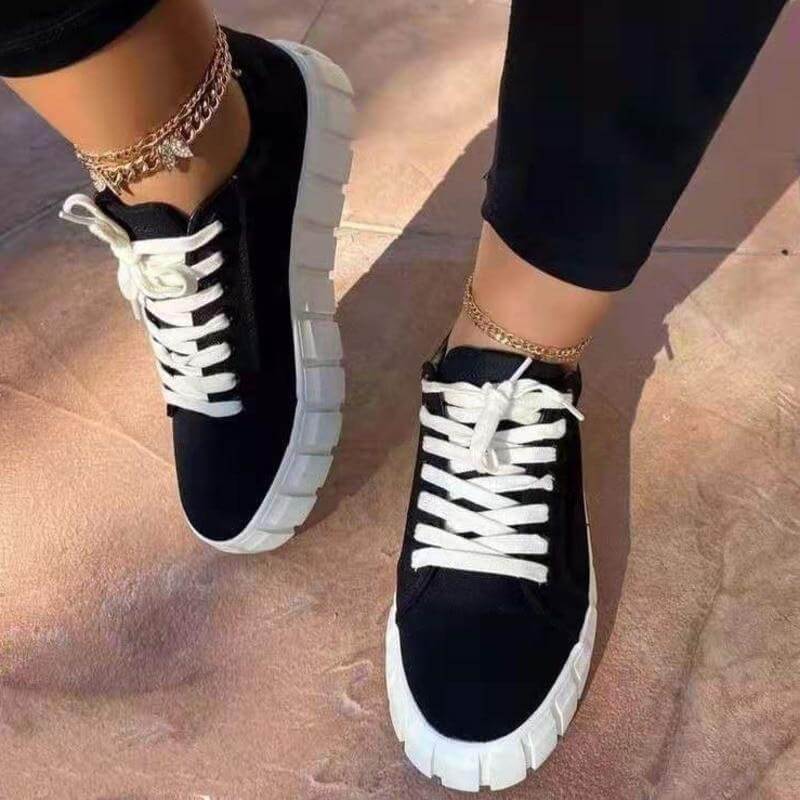 Black platform sneakers with white laces, perfect for casual outfits and stylish comfort.
