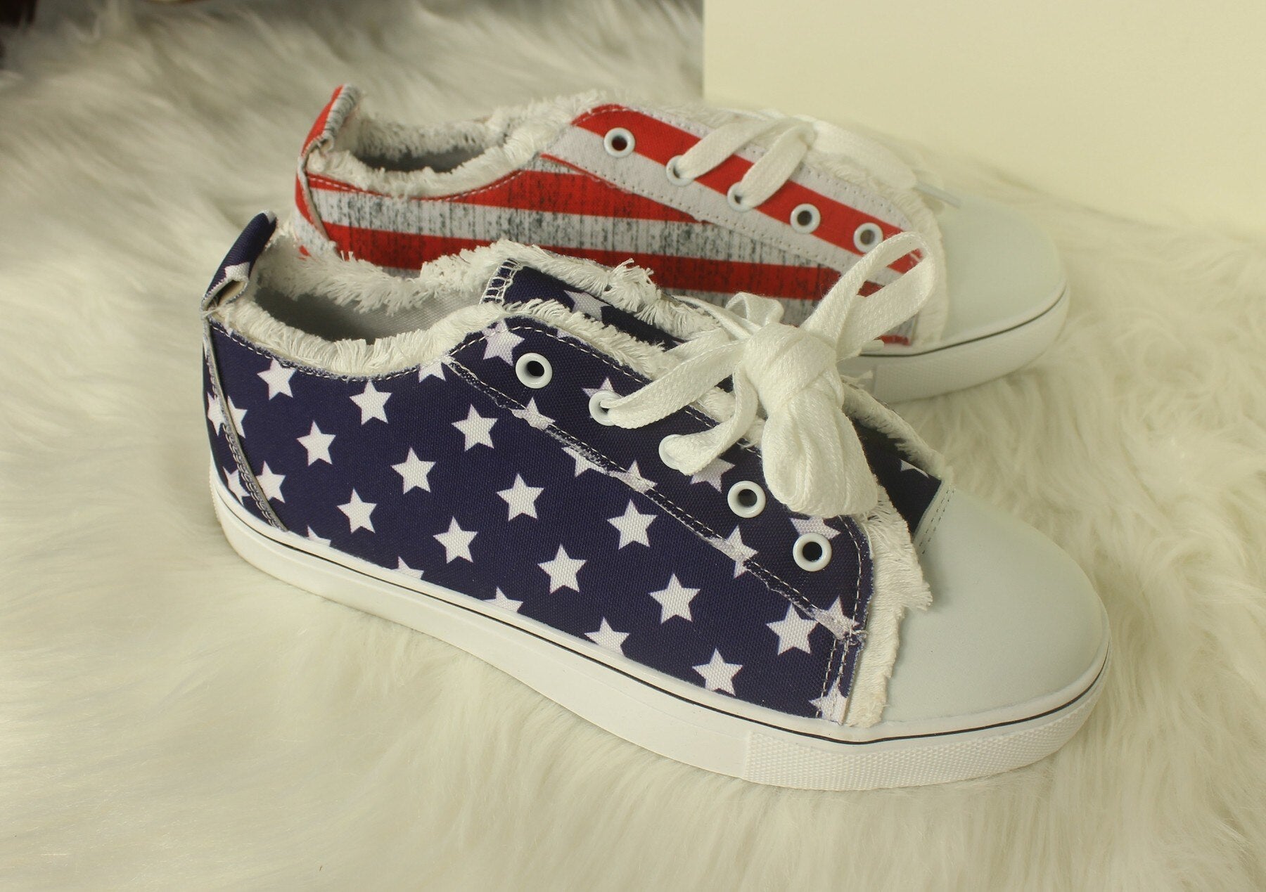 Star striped lace-up sneakers featuring a round toe design with navy and red star patterns, perfect for casual wear.