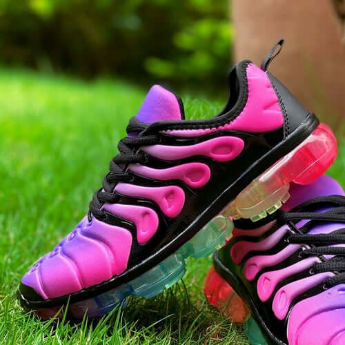 Stylish pink and black running trainers with bubble sole on green grass, perfect for summer workouts.