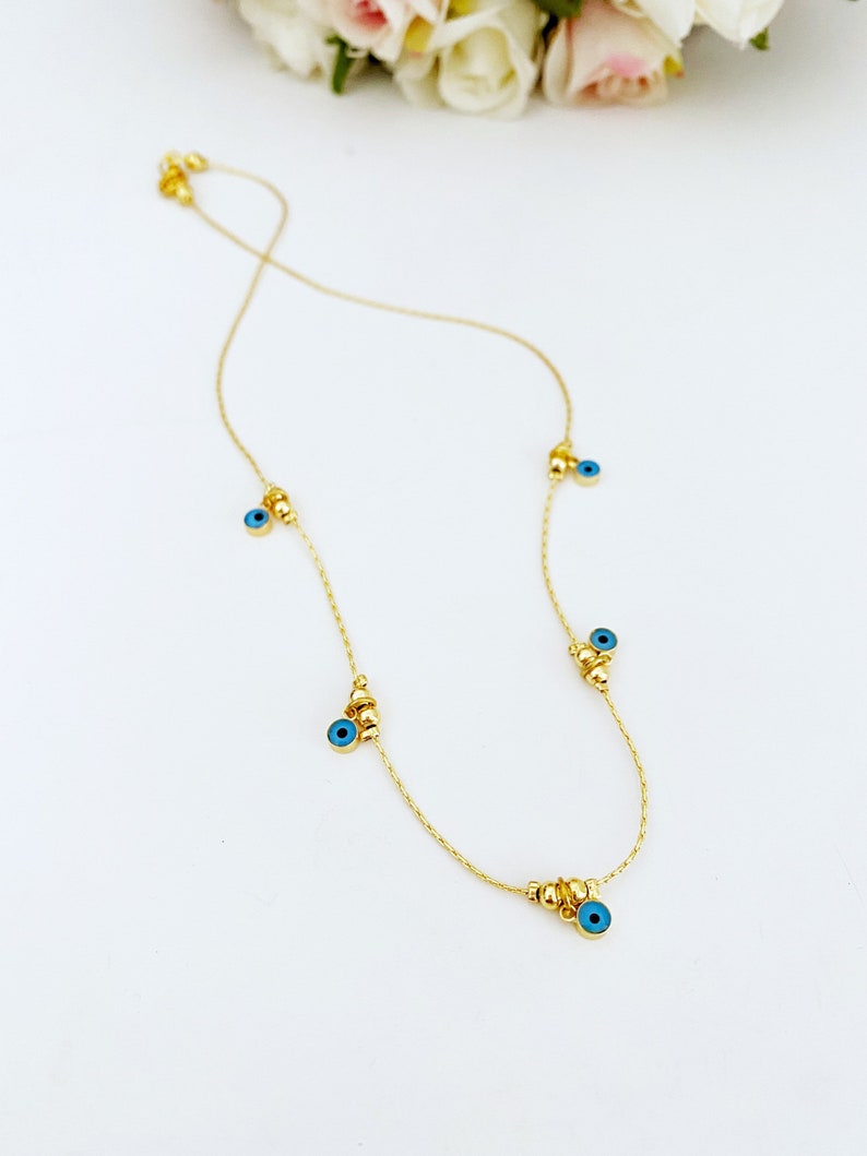 Dainty blue evil eye necklace on gold chain, view 2