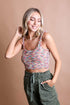 Smiling model wearing the Whimsical Boucle Brami top with colorful boucle design and casual green pants.