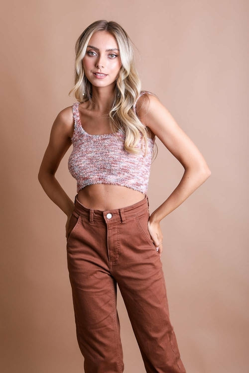 Model wearing a cozy pink Whimsical Boucle Brami with high-waisted brown pants, radiating playful style.