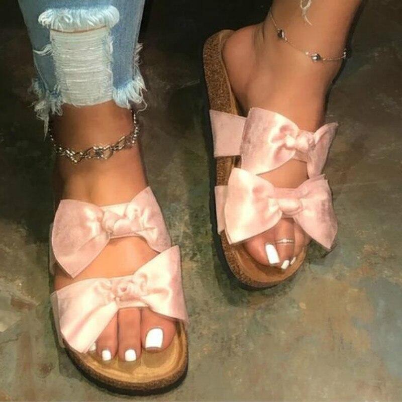 Stylish pink bow slide sandals for women, featuring comfy two straps ideal for summer outings.