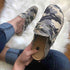Stylish camouflage canvas loafers with a flat heel, showcasing vintage charm and comfort on a cozy surface.
