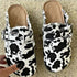 Trendy black and white cow print canvas loafers with a casual open back design.