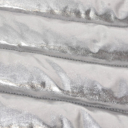 Close-up of shiny metallic silver fabric with quilted texture, highlighting softness and warmth.