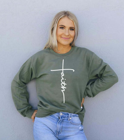 Woman wearing a green Faith Sweatshirt, showcasing stylish design and comfortable fit for casual occasions.