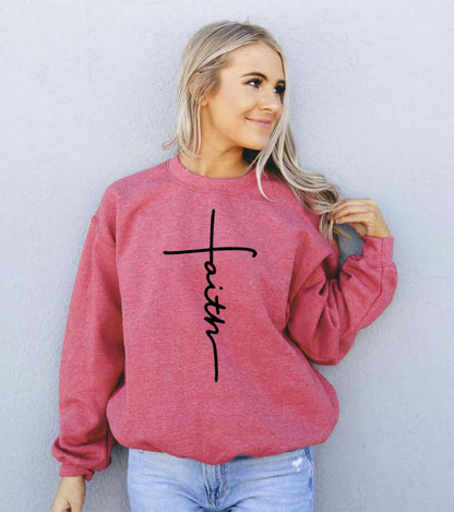Model wearing a stylish red Faith Sweatshirt, featuring a trendy script design, perfect for casual occasions.