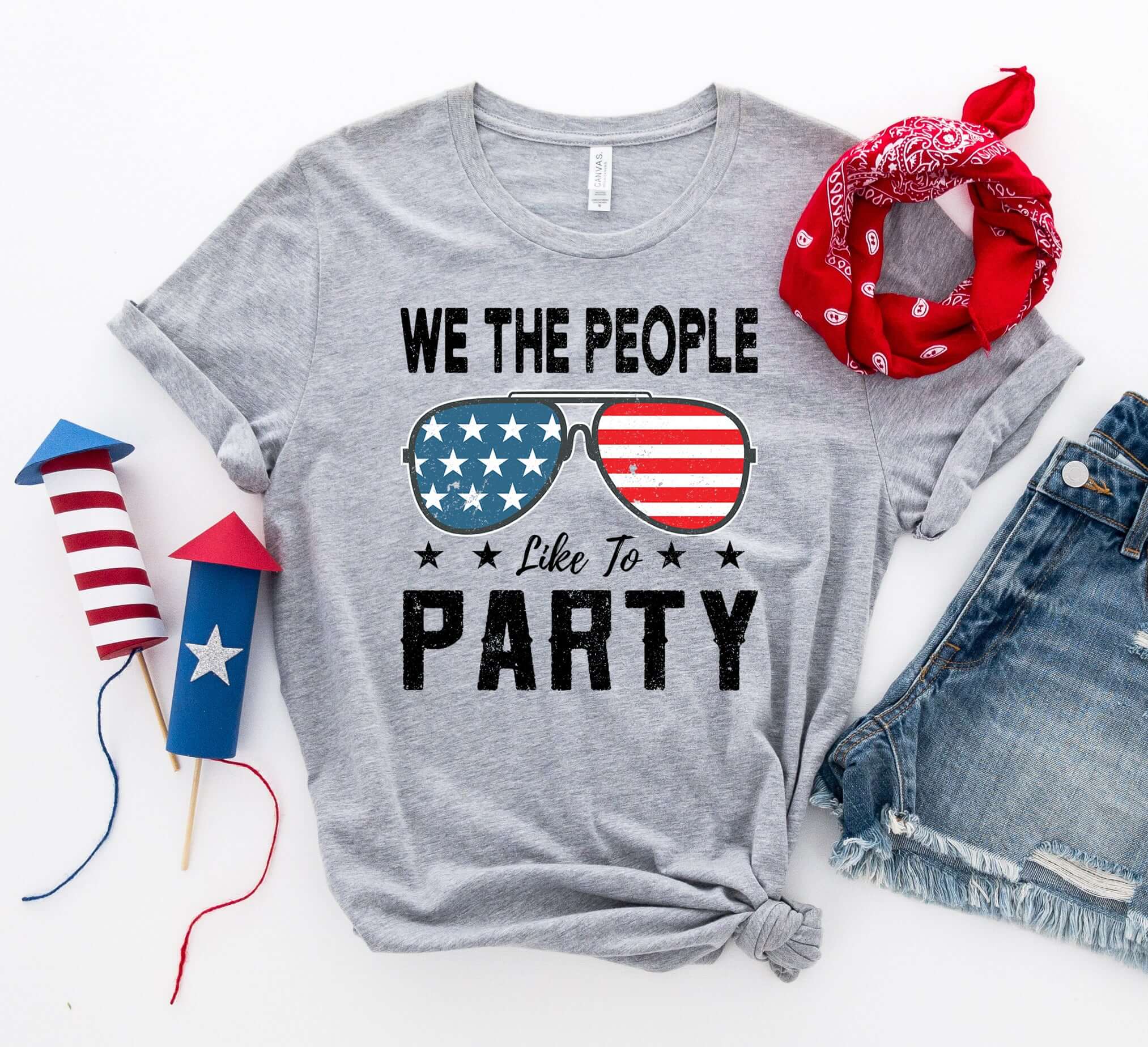 We the People Like to Party T-shirt with patriotic sunglasses design, styled with bandana and festive accents.