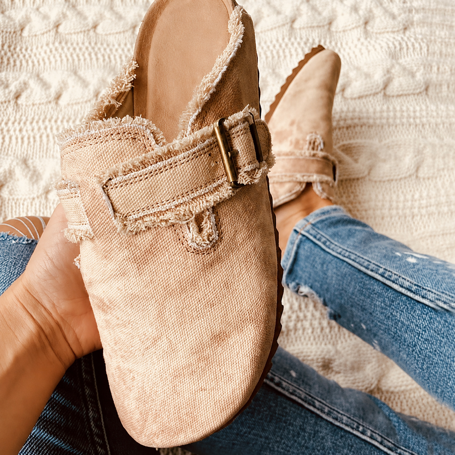 Close-up of vintage-style beige canvas loafers with a buckle, perfect for retro fashion lovers.