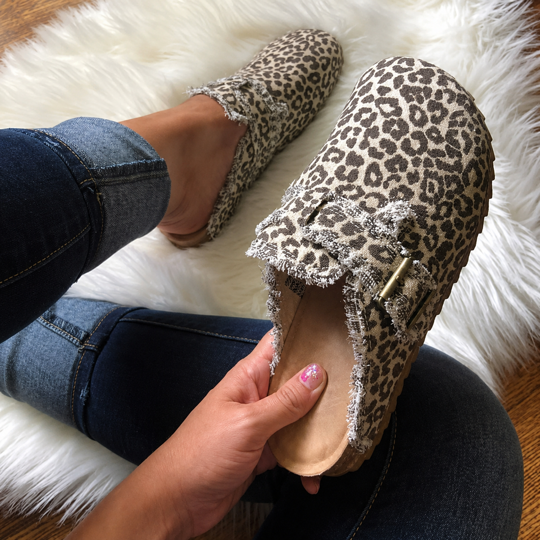 Fashionable leopard print canvas loafers in hand on cozy rug, styled for a chic vintage look.